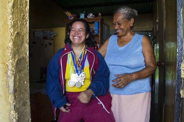 Foto de joven con sindrome de Down cargada de medallas y su abuela