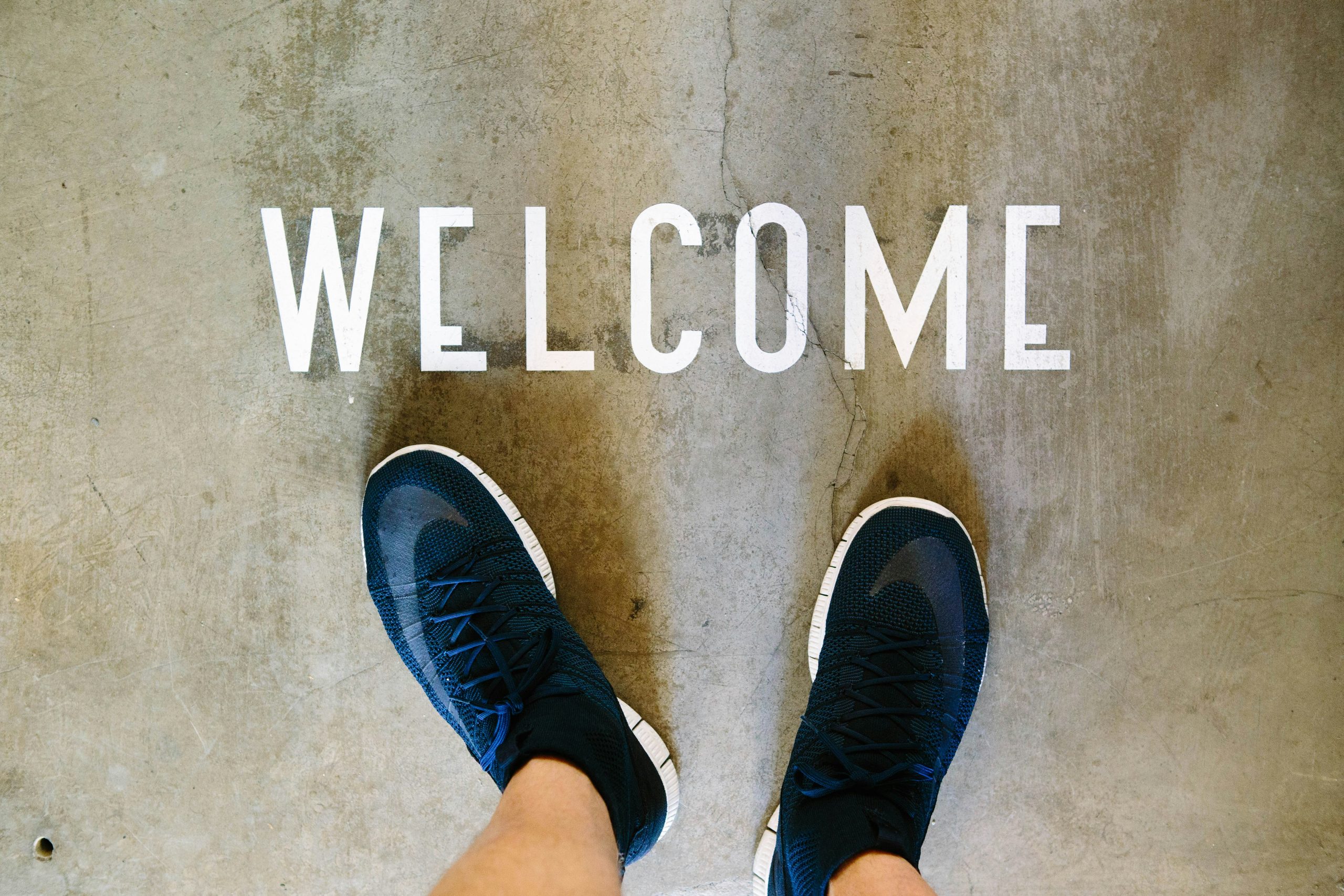 Welcome sign on the floor, representing the first step in helping newcomers feel comfortable joining a conversation group.