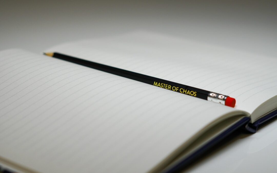 Black pencil resting diagonally across the lined pages of an open notebook.